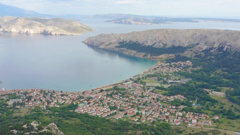 Aerial arc shot high above the town of Baska on Krk Island, Croatia looking out to sea.