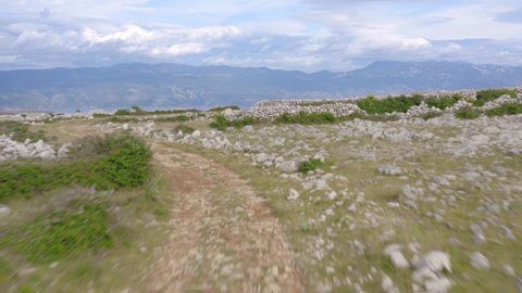 Fast and low aerial flyover of the moon plateau on Krk Island, Croatia on a cloudy day