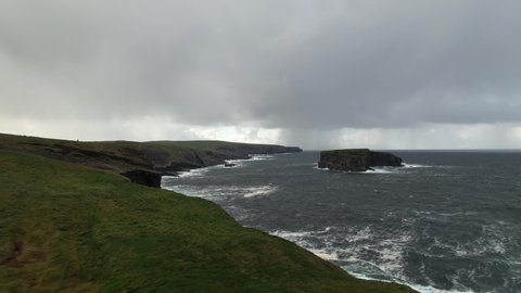 Kilkee Cliffs, Clare County, Ireland. Aerial View of Scenic Coastline, Cliffs and Waves on Moody Day Drone Shot