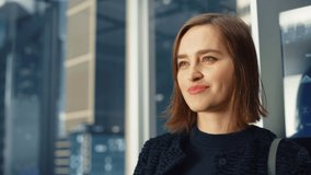 Portrait of Successful Businesswoman Riding Glass Elevator to Office in Modern Business Center. Young Beautiful Female Looking at Modern Downtown Skyscrapers Out of the Panorama Window in the Lift. - Powered by Shutterstock - Get 15% off with code: PIKWIZARD15