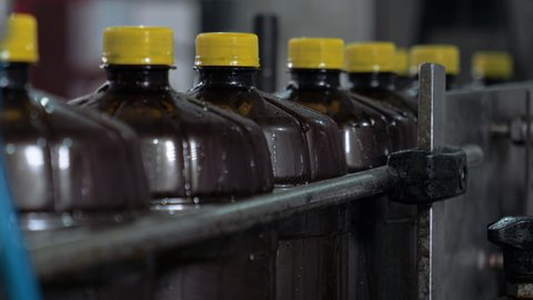 Plastic Bottles With Beer Moving In Row At Production Factory At Close Up. Plastic Bottles On Conveyor Line At Manufacturing Plant. Plastic Bottles For Traditional Slavic Beverage.