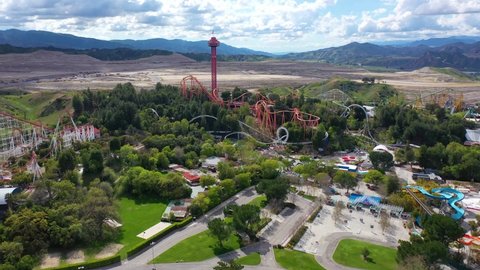 USA: California March 21, 2020. Aerial flight over Six Flags Magic Mountain theme park, rollercoaster rides and mountains in the background. Theme park closed due to COVID