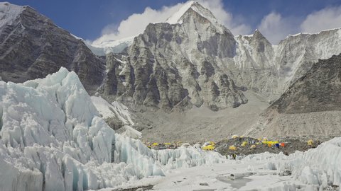 Panorama. Yellow tents at Everest Base Camp in snow mountains. Khumbu glacier