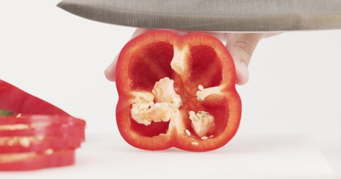 The chef uses a knife to cut the red bell peppers in half. The slides are beautifully arranged.
