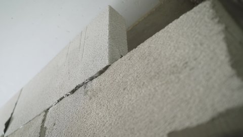 Construction of a wall from aerated blocks. A construction contractor is leveling an aerated concrete wall.
