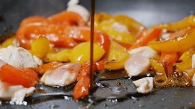 add soy sauce to the pan where we fry the meat with red and yellow bell peppers and onions. For Korean noodles. Slow motion, dolly shot - Powered by Shutterstock - Get 15% off with code: PIKWIZARD15