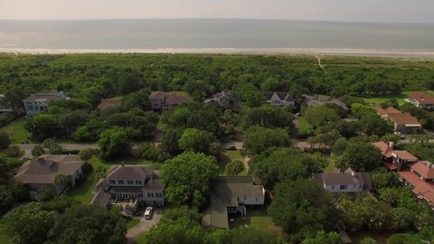 Luxury homes in a coastal neighborhood by a marshland and sandy beach