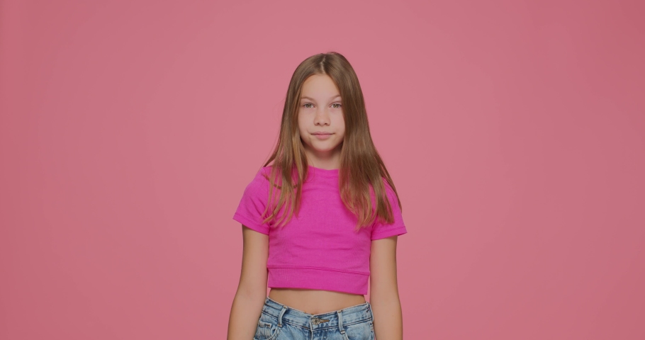 Frightened child girl covering eyes with hands and doing stop gesture with fear expression on pink studio background Royalty-Free Stock Footage #1084342060