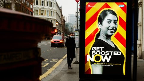 LONDON, circa 2021 - A billboard poster is seen in Central London urging people to get boosted against COVID-19, as the Omicron variant rages on

