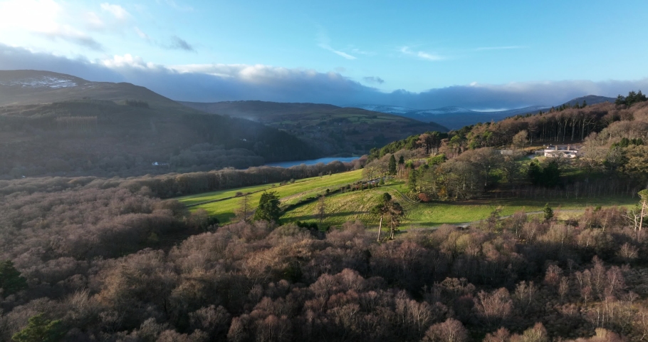Lough Dan, Wicklow, Ireland. December 2021 Drone slowly pushes northwest above Carrigroe towards the lake with snow-capped mountains in the distance.