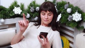 A woman using a smartphone choosing gifts in the application. Woman emotionally using the phone, gesturing, raising her finger up. Online shopping concept. Online communication concept