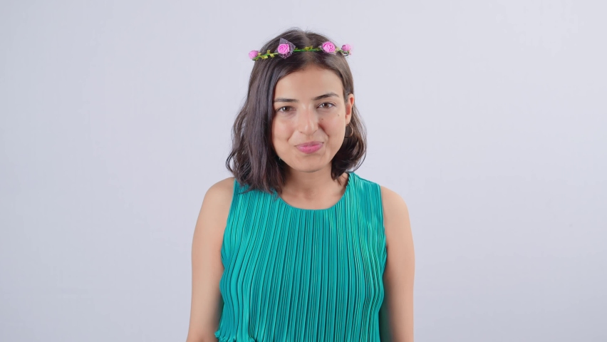 Young Asian Indian cheerful attractive woman wearing a floral tiara on head with a smile on her face standing isolated on white background. Concept of self-love, success, achievement, and leadership 