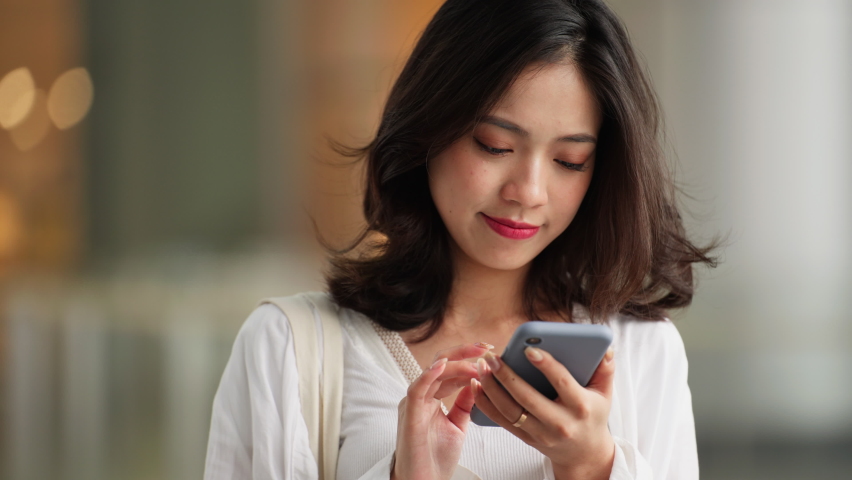 Slow motion of pretty young asian woman using mobile phone in the urban shopping mall Royalty-Free Stock Footage #1084362436