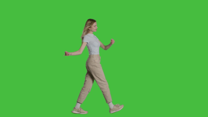 Casual young blonde woman walking. Shot on a mock-up green screen in the background. 4k uhd video on Chroma key