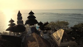 Beautiful Balinese temple perched on top of mountain cliff on background scenery natural landscape Nusa Dua Beach, Bali, Indonesia. 4K UHD Video Clip. Aerial view.
