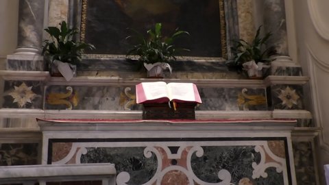 Zooming in on open English language Holy Bible book on altar in the Christian church.
