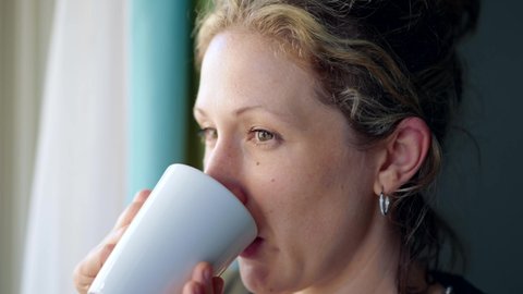 Thoughtful Young Woman Enjoying Cup Of Coffee Feeling Positive