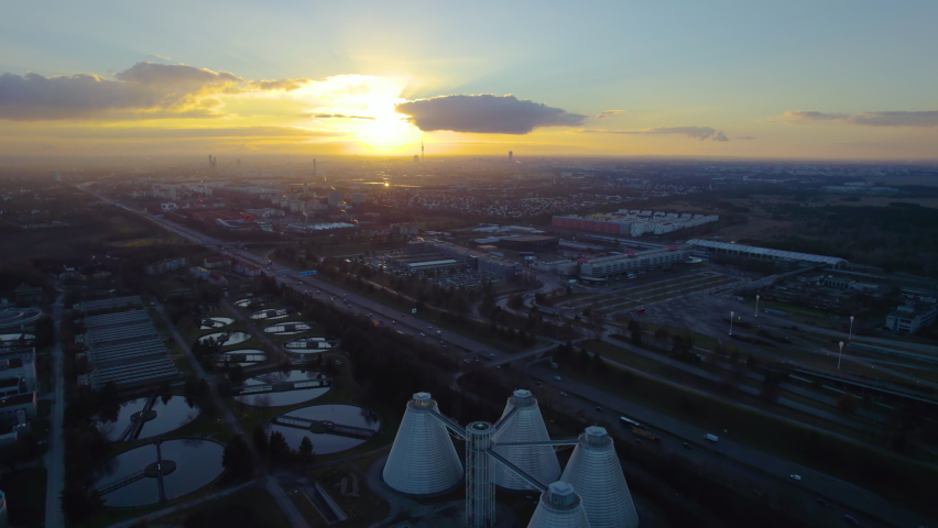 Munich aerial skyline view at sunset colored sky, munich aerial top view birds eye view from distance munich tv tower olympia park view. Germany autobahn. Royalty-Free Stock Footage #1084374334