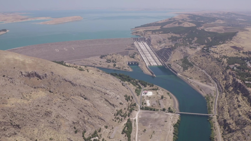 Dam water runs through the dried hills. 