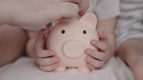 budget of a happy family, a hold on the future of life, a family security pillow, a pig piggy bank collects money, father and mother give cash a child, the concept of a child's dream of saving coins