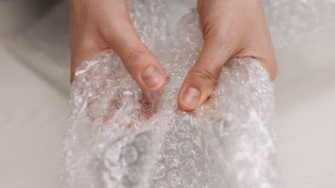 Woman's hands pressing hard on a bubble paper. Girl pressing the bubble wrapping. Stress concept