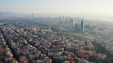 Panoramic aerial view of Barcelona cityscape with octagon buildings. Streets and blocks, urban traffic. Morning, fog. Picturesque seascape. Tourism, travelling. Catalonia, Spain. Slow motion