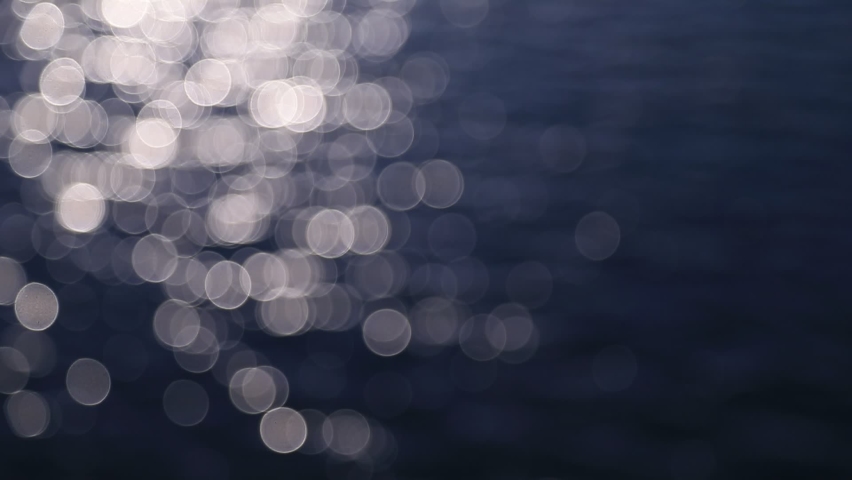 Abstract motion of the sunrise sea, shimmering water defocused background, bokeh effect