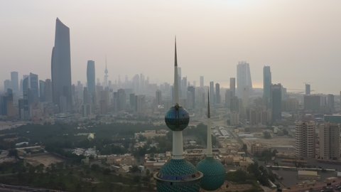 Kuwait City, Kuwait - February 24, 2020: Aerial view of Kuwait City. Camera slides behind Kuwait Towers and financial district on the background in sunrise after sand storm.