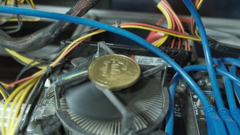 Graphic cards with motherboard and BTC golden coin on processor Ehtereum Crypto mining rig