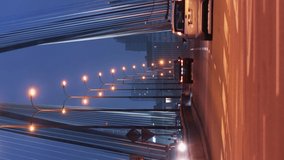 Vertical video time-lapse cars traffic jam on road in city in evening. Timelapse rush hour busy crossroad by bridge roadway downtown. Cars at night, lights in fast motion. Lights trails fast motion