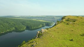 Majestic view of the river canyon and green hills from a bird's eye view. Location Dniester River, Ukraine, Europe. Cinematic drone shot. Filmed in UHD 4k video. Discover the beauty of earth.