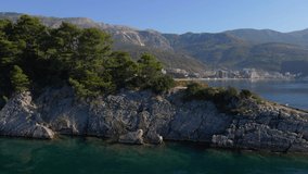 Slowmotion aerial video. The city of Budva, view on the Bechichi or Becici beach, a popular tourist place in Montenegro. Revealing shot