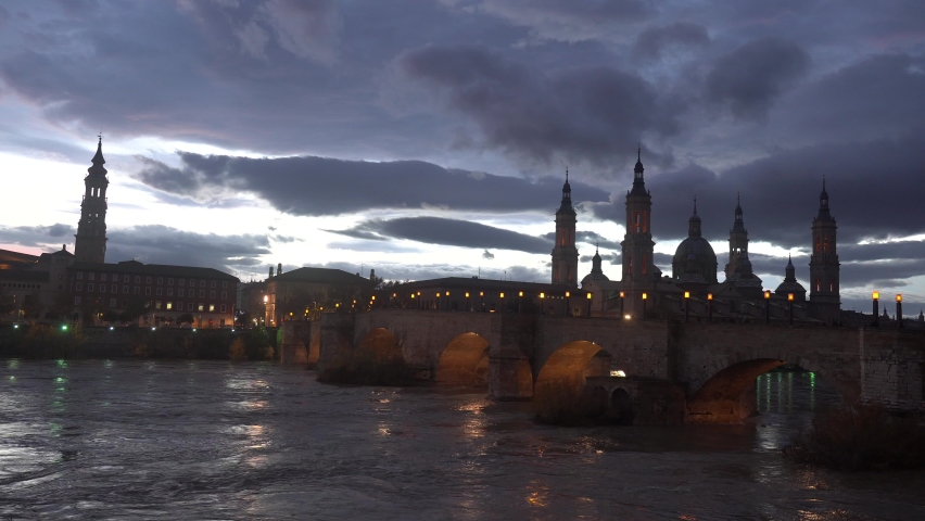 Blue hour on the Piedra bridge next to the Basilica De Nuestra Senora del Pilar on the Ebro river in the city of Zaragoza, Aragon. Spain. Video 4k