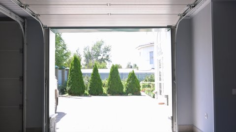 Lifting automatic gates. An automatic garage door opens, revealing a view of the courtyard. Lifting the door with roller shutters