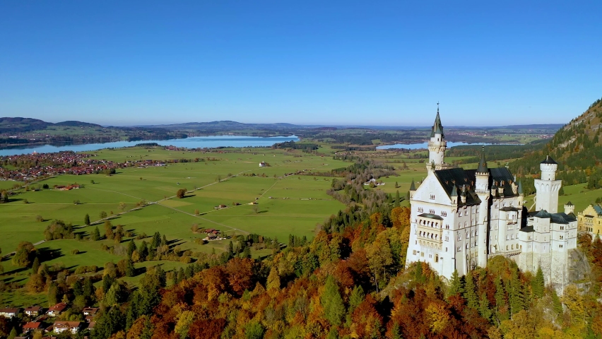 Flying over Neuschwanstein castle with Autumn color trees