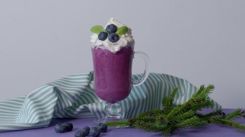 Camera Bump on Blueberry smoothie on violet gray. Shades of Very peri, lilac, purple, lavender, Barvinok. Whortleberry striped napkin. Color of year 2022. French dessert. Inspired 17-3938