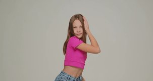 Stylish little child girl dancing having fun, cool moving. Energetic schoolgirl performing, showing modern dance