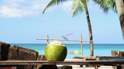 Coconut juice with straw tropical island. Coconut drink on beach during sunset. 
