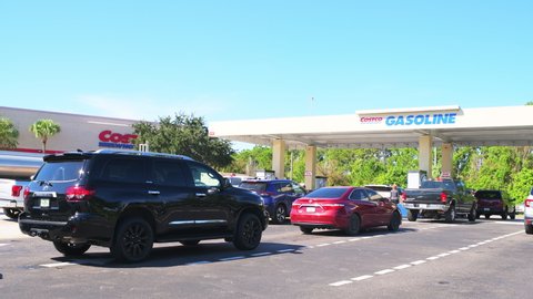 Naples, USA - October 4, 2021: People in cars waiting in long line queue lanes to fill up vehicles with gasoline fuel at Costco gas station of Florida