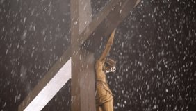 video snow is falling against the background of Jesus Christ hanging on the cross