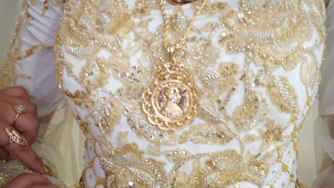 The bride's dress is decorated with gold. Gold medallion on the bride's dress. Gypsy wedding