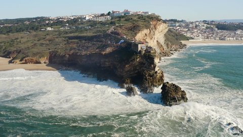 Aerial drone view of strong Atlantic ocean waves and cliff coast in Nazare, Portugal