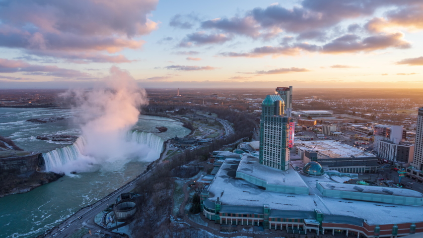 Aerial view of Niagara Falls City downtown horizon and Horseshoe Falls. Time-lapse photography in a  winter sunny day sunset time.