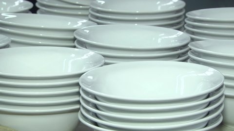 Porcelain factory production of mugs and plates in shelf stacks. Ceramic product rolls in ceramic factory. Earthenware process manufacturing