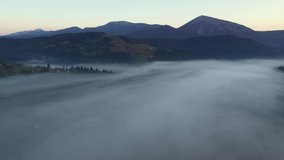Gorgeous rural landscape is covered with thick morning fog. Location place Carpathian mountains, Ukraine, Europe. Cinematic aerial drone shot. Filmed in UHD 4k video. Discover the beauty of earth.