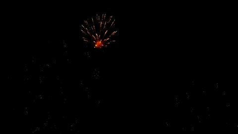 Slow-motion footage of real fireworks show adorns the black sky, golden sparks shine and disappear into the night.