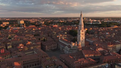 modena city center and cathedral aerial view drone,flying orbit over grande square cathedral and ghirlandina tower at sunrise