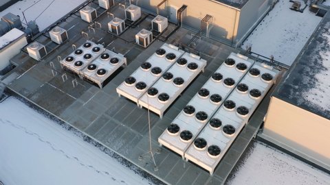 Heating, ventilation and air conditioning systems installed on a snow-covered rooftop. Aerial  view