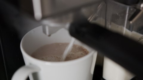 Making Cappuccino or Caffe Macchiato, Close Up of Warm Milk and Coffee in Cup