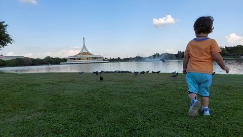 Bangkok, Thailand - 12 24 2021: Domestic tourist visiting the  famous Rama 9 park with lake and ideal for fish feeding and relaxation during corona pandemics.